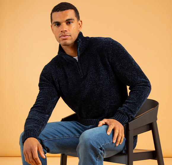 Seated male wearing a warm jumper.