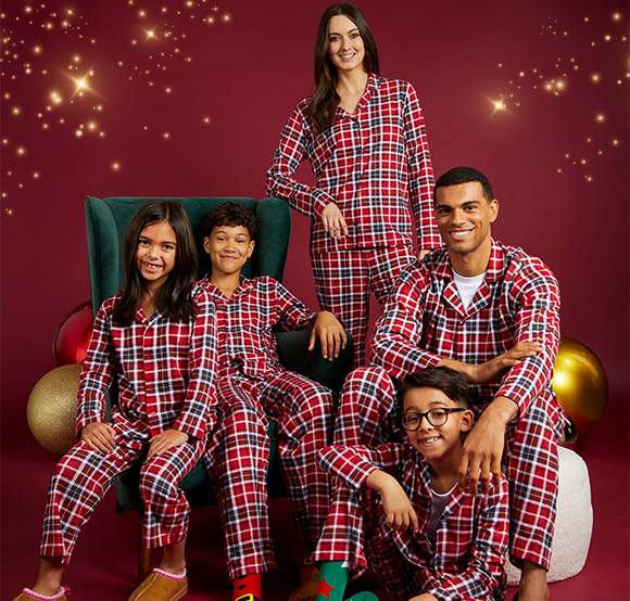 Family wearing matching red and blue Christmas pajamas.