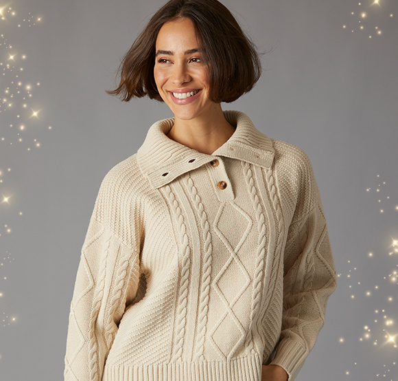 Crew Clothing cable knit jumper with a collared neckline featuring a diamond pattern, worn by a smiling model.