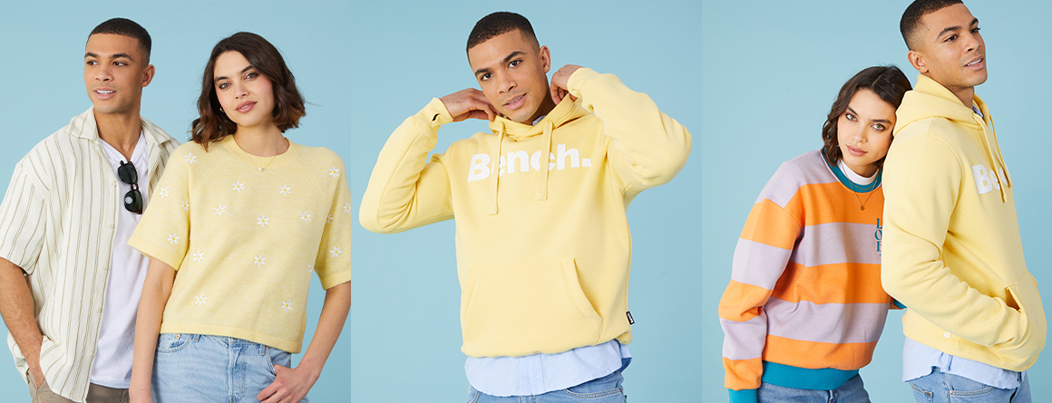 Male and female models sporting butter yellow tops, hoodies and jumpers.