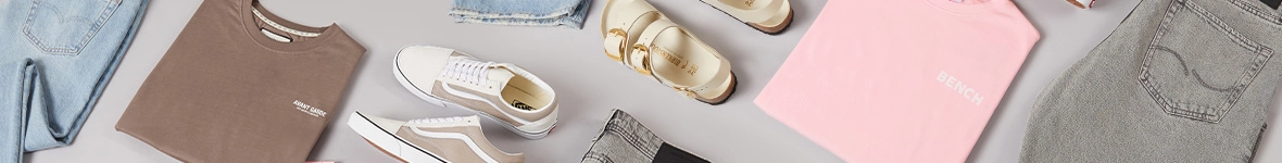 Casual fashion flat lay: light blue and grey jeans, brown and pink t-shirts, beige Vans sneakers, and cream sandals.