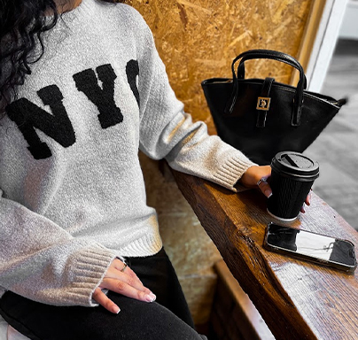Lady sat at cafe window with a cup of coffee.